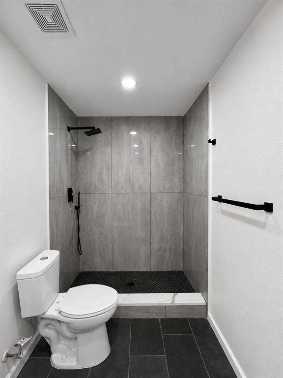 1842 Delmar Drive, Garland, TX 75040 Contemporary walk-in shower with vertical gray wall tiling, black penny tile shower floor, and matte black fixtures