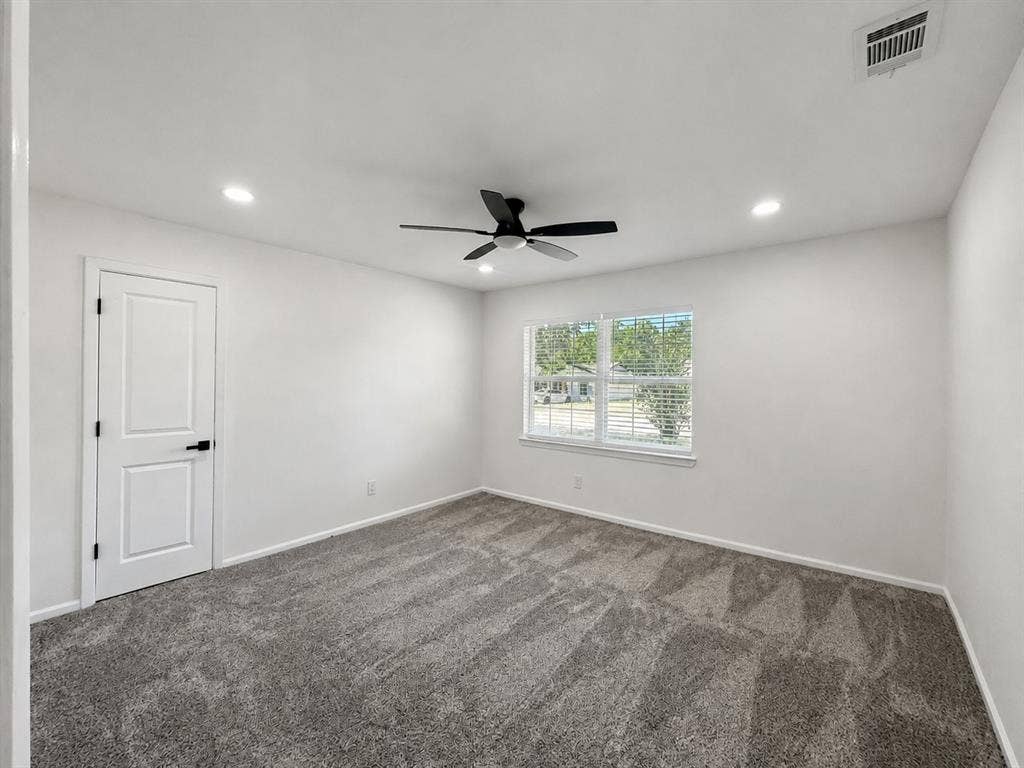 1842 Delmar Drive, Garland, TX 75040 Recessed lighting, ceiling fan, white paneled door with black hardware, window with blinds, and gray carpeted flooring