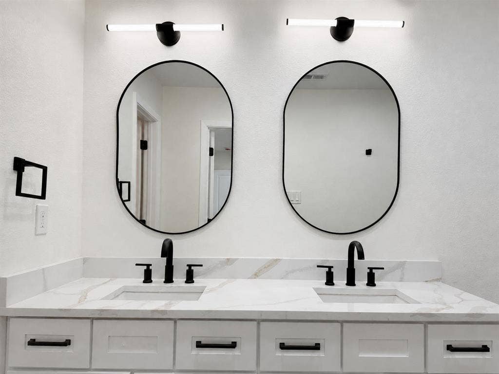 1842 Delmar Drive, Garland, TX 75040 Dual vanity with white shaker-style cabinetry, white countertops featuring veining, undermount sinks, and matte black fixtures