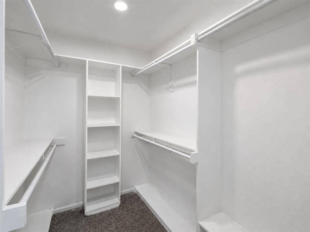 1842 Delmar Drive, Garland, TX 75040 Walk-in closet featuring built-in shelving, multiple hanging rods, and recessed lighting