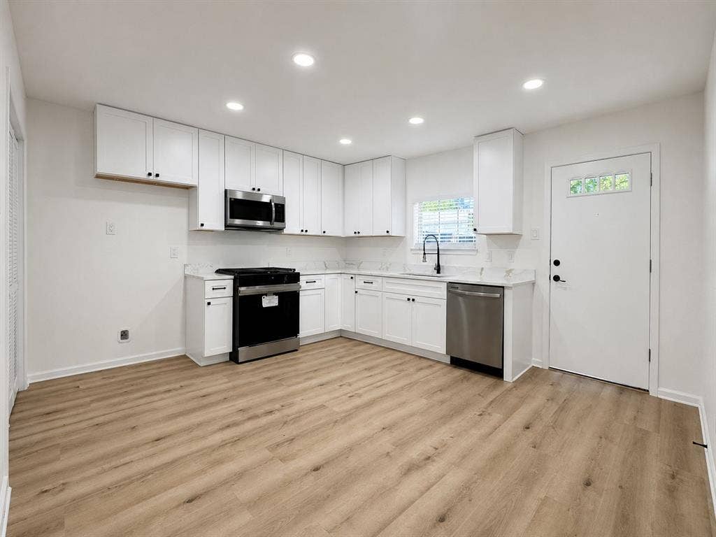 1842 Delmar Drive, Garland, TX 75040 Kitchen featuring white cabinetry, stainless steel appliances, wood-finish flooring, recessed lighting, and a window above the sink