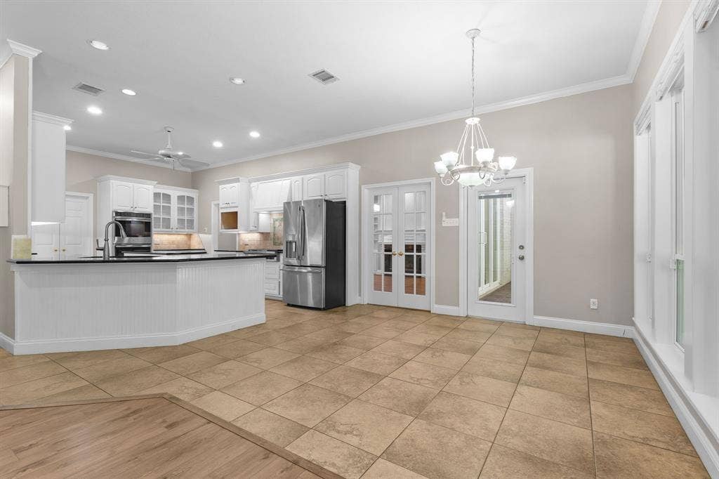 367 Elm Grove Circle, Waco, TX 76657 Kitchen featuring white cabinetry, stainless steel appliances, dark countertops, and a peninsula with beadboard detailing