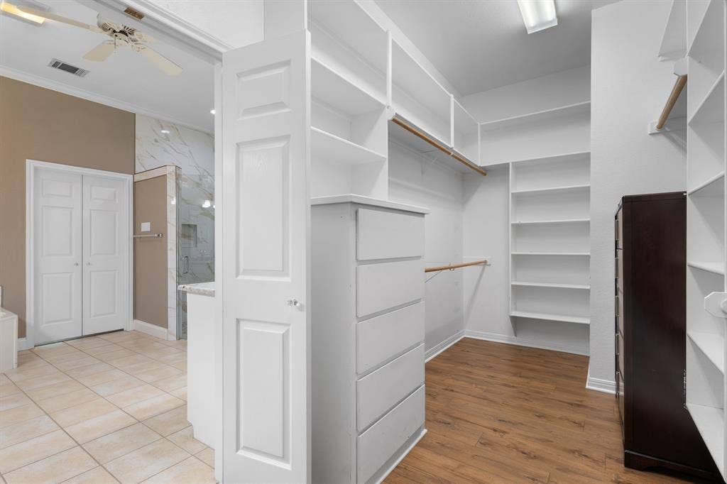 367 Elm Grove Circle, Waco, TX 76657 Walk-in closet featuring extensive built-in shelving, wood-finish flooring, and integrated drawer storage
