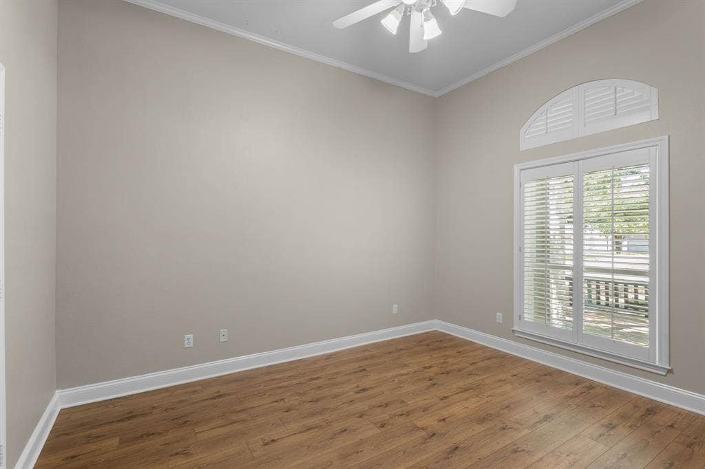 367 Elm Grove Circle, Waco, TX 76657 Wood-finish flooring, crown molding, ceiling fan, and arched transom window with plantation shutters