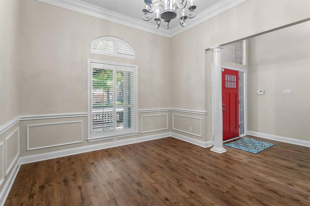 367 Elm Grove Circle, Waco, TX 76657 Wood-finish flooring, wainscoting, crown molding, arch window, and a red paneled entry door
