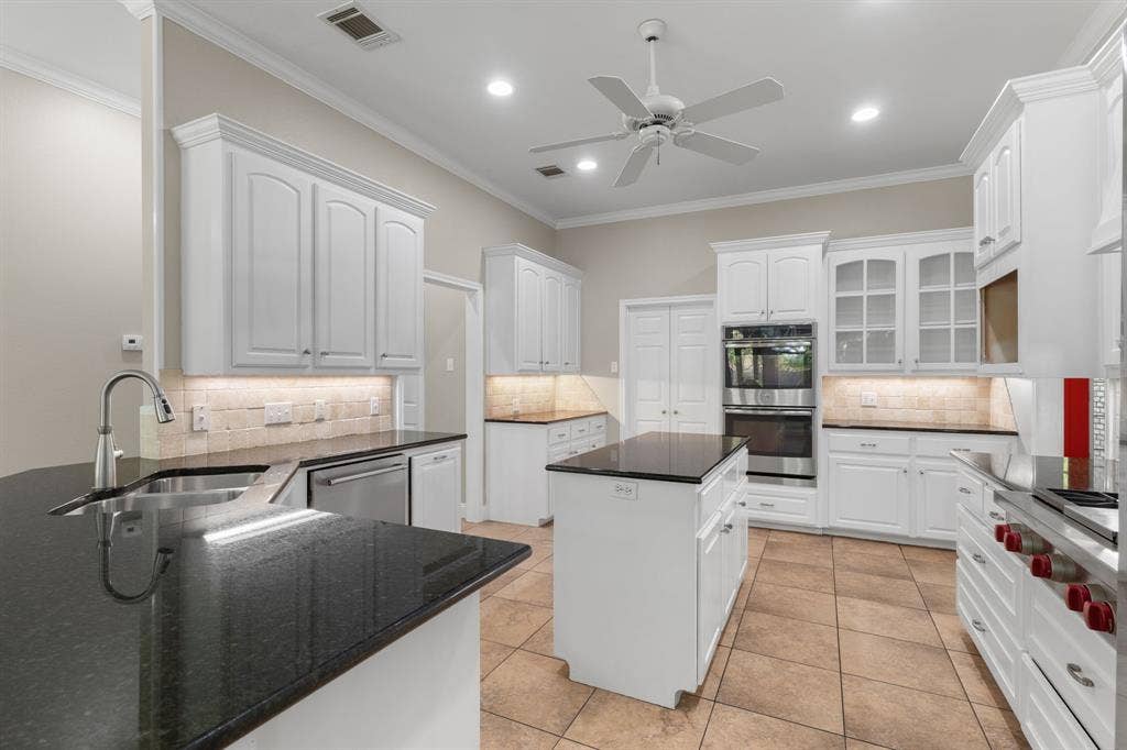 367 Elm Grove Circle, Waco, TX 76657 Kitchen with white cabinetry, black stone countertops, stainless steel appliances, a center island, and tile flooring