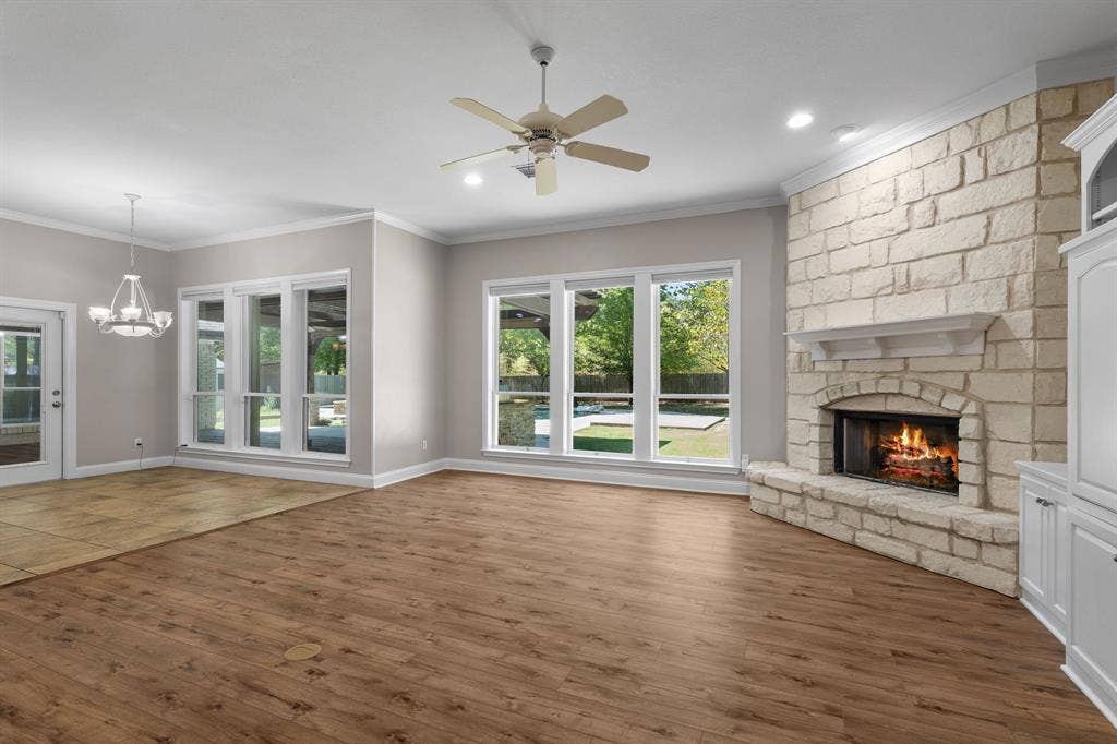 367 Elm Grove Circle, Waco, TX 76657 Spacious living area featuring wood-finish flooring, a stone-clad fireplace with a mantel, white built-in cabinetry, and multiple windows