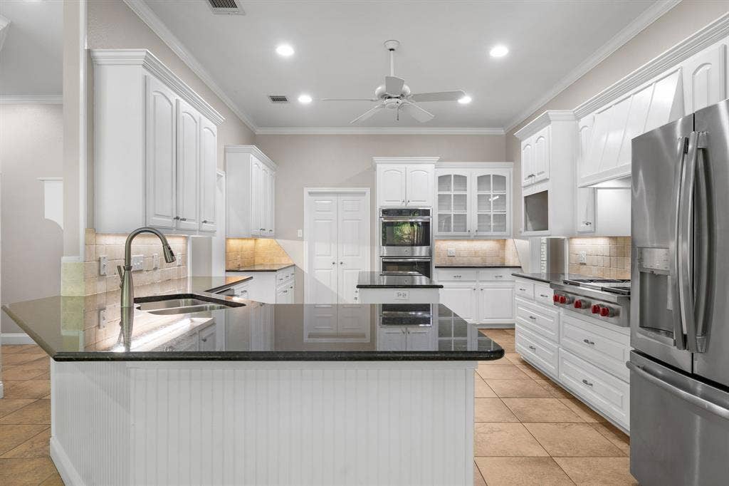 367 Elm Grove Circle, Waco, TX 76657 Gourmet kitchen with white cabinetry, stainless steel appliances, stone countertops, integrated sink, and tile flooring