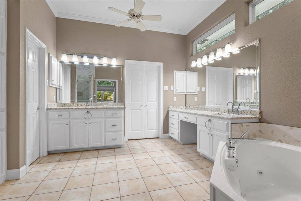 367 Elm Grove Circle, Waco, TX 76657 Dual vanity with white cabinetry, granite countertops, tile flooring, and a built-in jetted tub