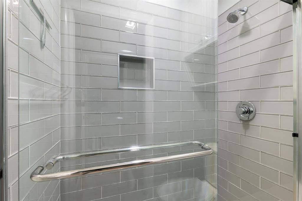 367 Elm Grove Circle, Waco, TX 76657 Glass-enclosed shower with subway tile surround, built-in storage niche, and polished chrome fixtures