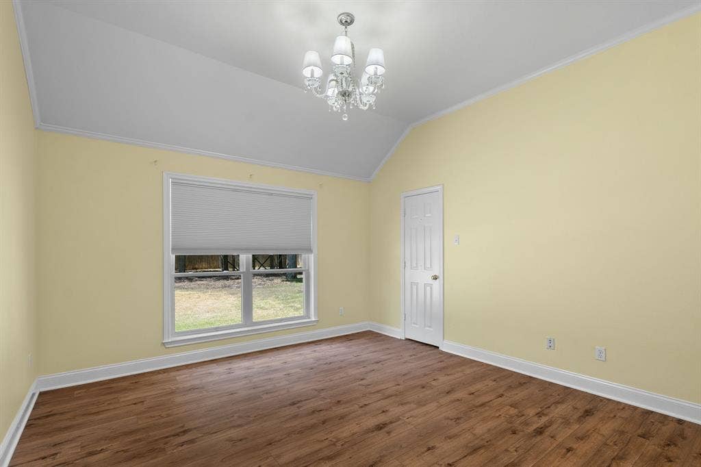 367 Elm Grove Circle, Waco, TX 76657 Vaulted ceiling with a crystal chandelier, wood-finish flooring, and a window with a cellular shade