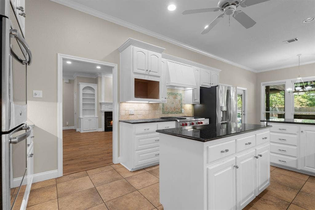 367 Elm Grove Circle, Waco, TX 76657 White cabinetry with dark countertops, a central island, stainless steel appliances, and tile flooring