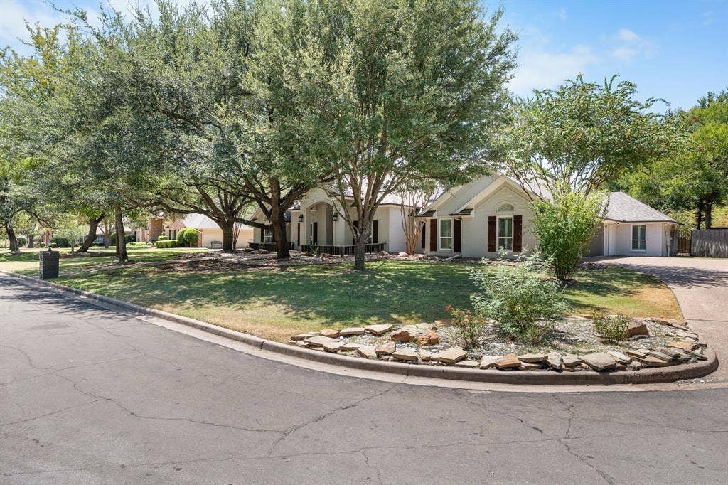 367 Elm Grove Circle, Waco, TX 76657 Single-story residence with a light-colored exterior, an attached garage, and a peaked roofline