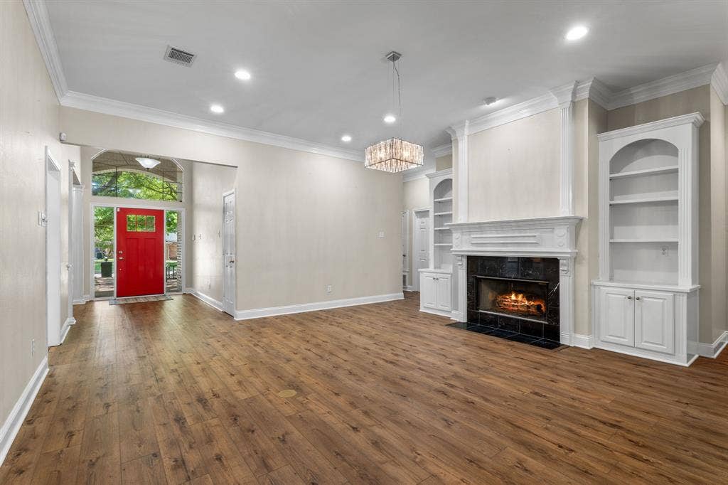 367 Elm Grove Circle, Waco, TX 76657 Wood-finish flooring, recessed lighting, crown molding, a decorative fireplace with a dark tile surround, and built-in shelving