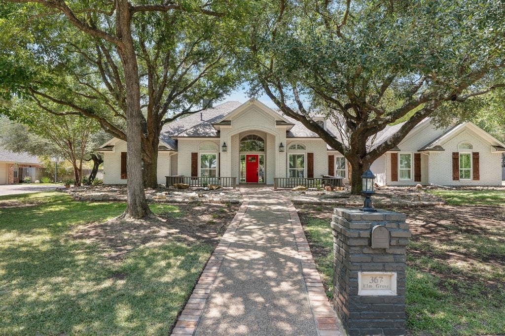 367 Elm Grove Circle, Waco, TX 76657 White exterior residence featuring a prominent red entry door, arched transom window, and multiple windows with brown shutters