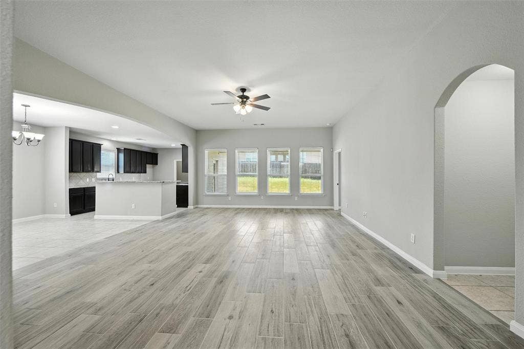Open-concept living area with wood-finish flooring, recessed lighting, and a ceiling fan