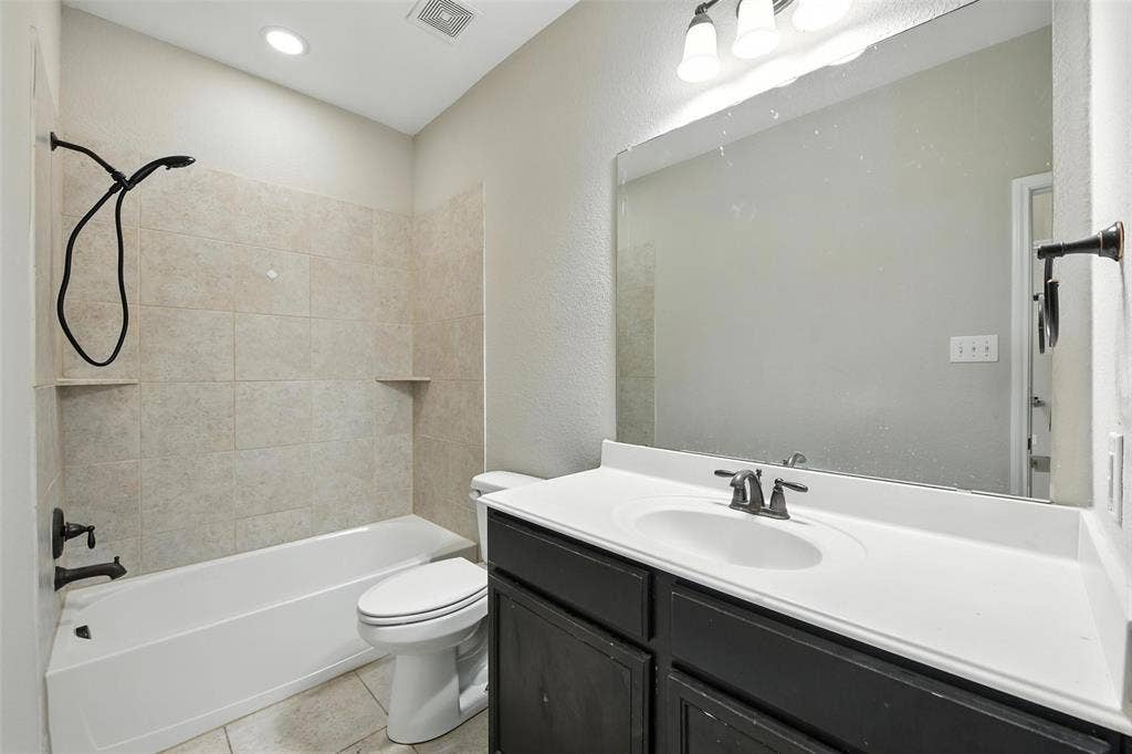 Modern bathroom featuring a dark wood-finish vanity with a white quartz countertop, rectangular undermount sink, and matte black faucet