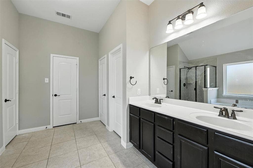 Dual vanity with dark wood-finish cabinetry and white countertops
