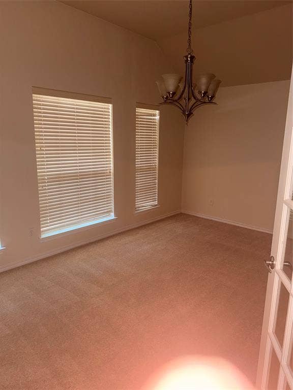1111 Whitaker Way, Glenn Heights, TX 75154 Carpeted room with a chandelier, multiple windows, and a paneled door
