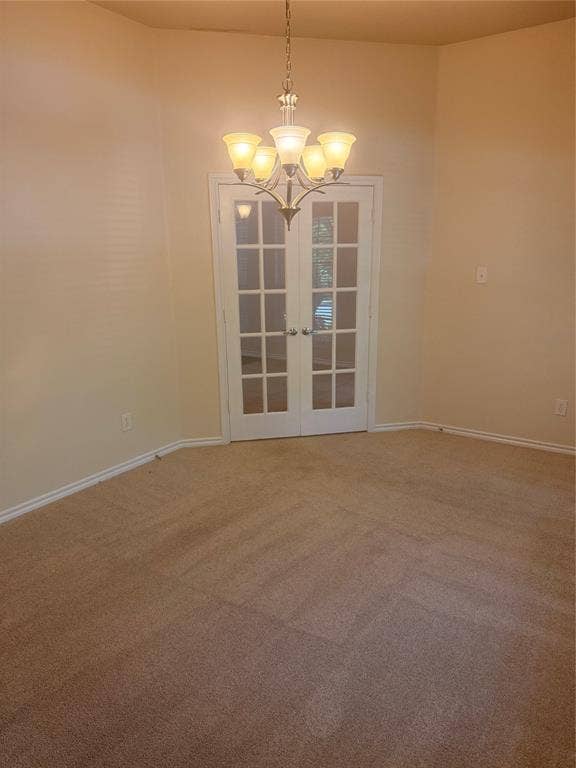 1111 Whitaker Way, Glenn Heights, TX 75154 Recessed alcove with carpet flooring, French doors, and a five-light chandelier