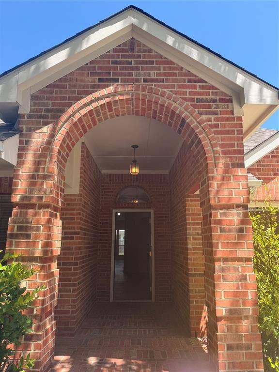 1111 Whitaker Way, Glenn Heights, TX 75154 Brick exterior with an arched entry, recessed lighting, and a hanging pendant fixture