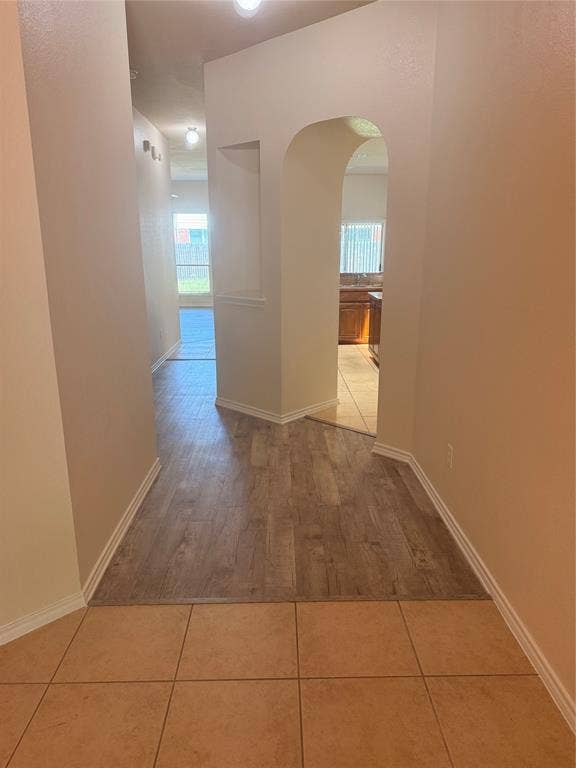 1111 Whitaker Way, Glenn Heights, TX 75154 Arched doorway leading to a kitchen with wood cabinetry