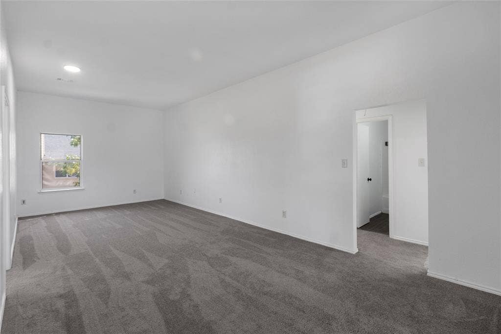 408 Centennial Place, Crowley, TX 76036 Spacious room featuring neutral carpeting, white walls, a recessed ceiling light, and a window for ambient light