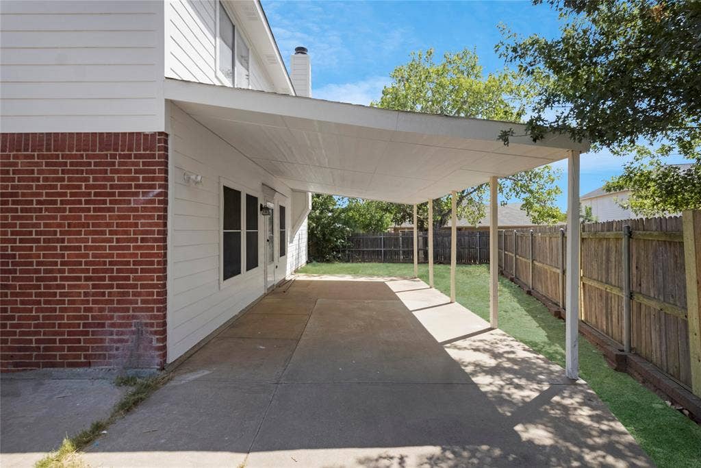 408 Centennial Place, Crowley, TX 76036 Expansive concrete patio with a covered outdoor area, offering direct access to the interior