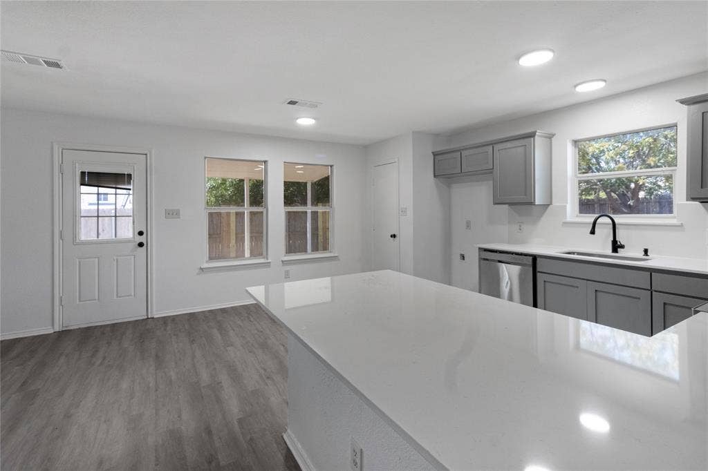 408 Centennial Place, Crowley, TX 76036 White quartz countertops, wood-finish flooring, recessed lighting, gray cabinetry, and a black gooseneck faucet