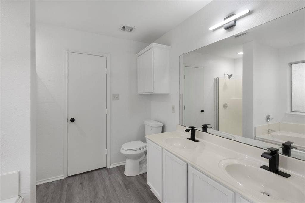 408 Centennial Place, Crowley, TX 76036 Bathroom featuring a dual vanity with undermount sinks, matte black faucets, and a large wall-mounted mirror