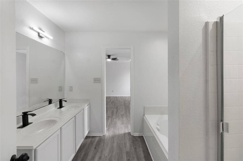 408 Centennial Place, Crowley, TX 76036 Spa-inspired primary bathroom featuring a dual-sink vanity with white cabinetry, black matte fixtures, and a quartz countertop
