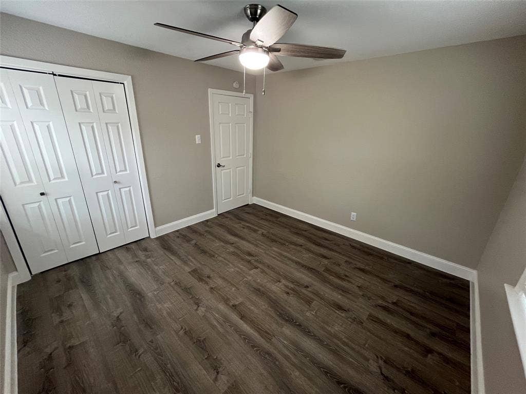 820 E Edith Street, Irving, TX 75061 Wood-finish flooring, neutral wall paint, and a ceiling fan with integrated lighting