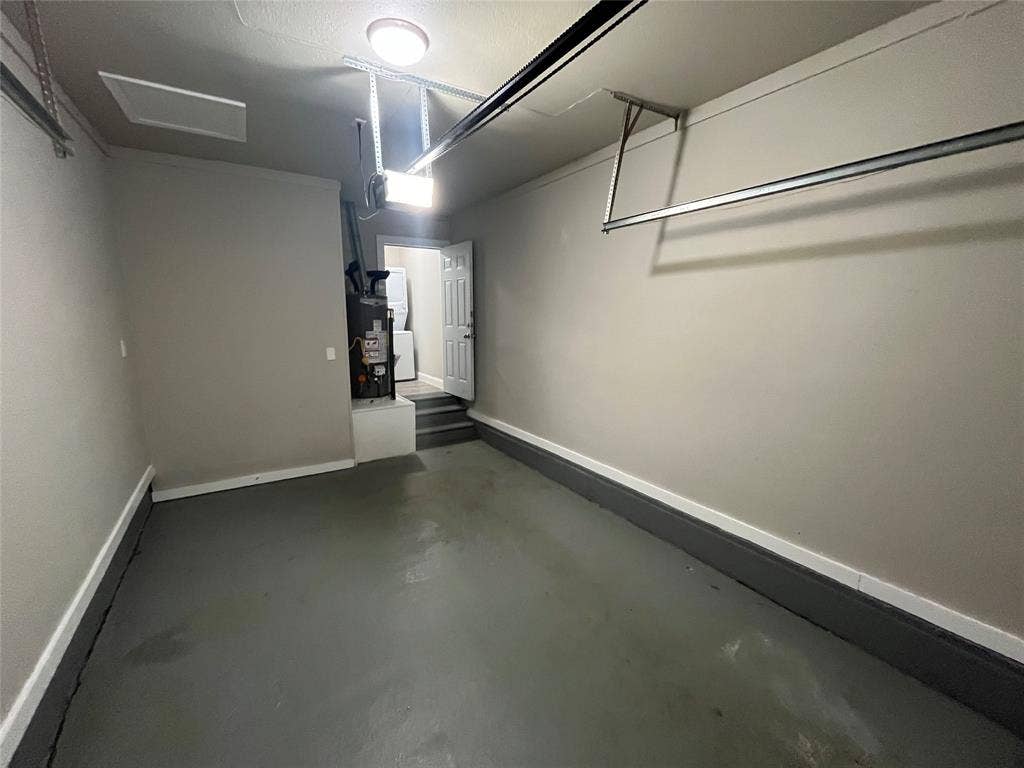820 E Edith Street, Irving, TX 75061 Single-car garage with painted concrete flooring, overhead lighting, and interior access door