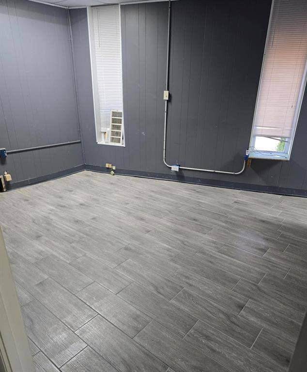 4309 Action Street, Garland, TX 75042 Wood-finish tile flooring, dark gray paneled walls, and two windows with blinds