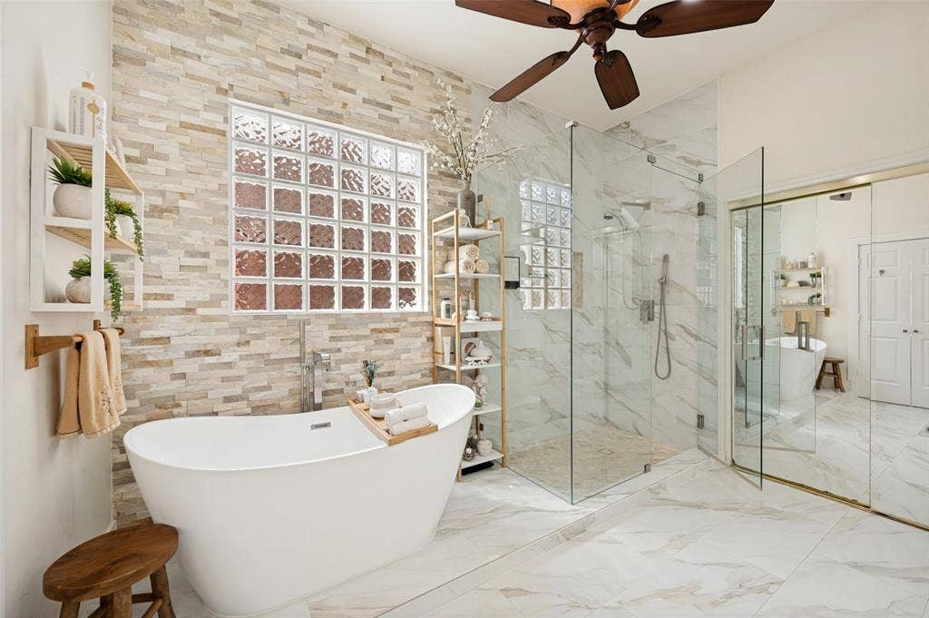 8524 Wellington Point Drive, Irving, TX 75063 Spa like soaking tub, floor-to-ceiling tiled accent wall with glass block window, frameless shower and a walk-in closet