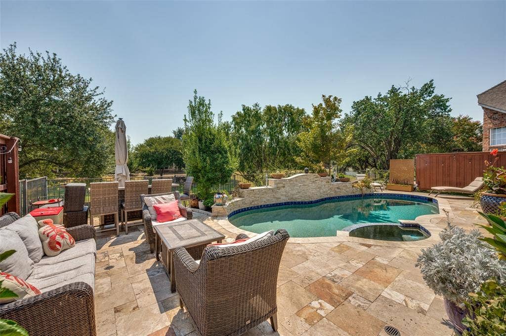 8524 Wellington Point Drive, Irving, TX 75063 Large Stone tile patio with a sparkling pool and integrated spa