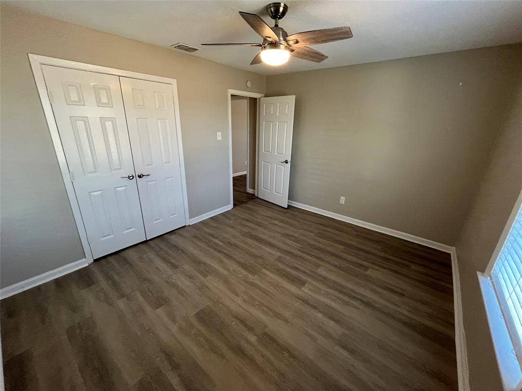 1843 Greendale Drive, Dallas, TX 75217 Wood-finish flooring throughout the room, featuring a ceiling fan with integrated lighting