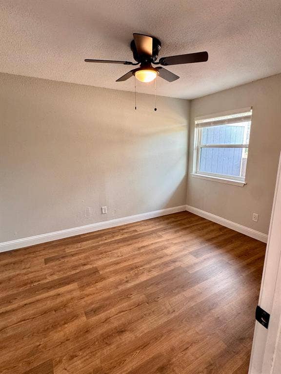 624 E 3rd Street, #202, Springtown, TX 76082 Wood-finish flooring, a ceiling fan with integrated lighting, and a white-framed window