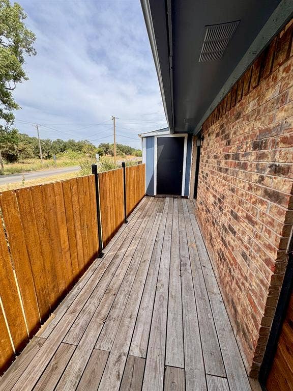 624 E 3rd Street, #202, Springtown, TX 76082 Brick exterior with a covered walkway and wood privacy fence