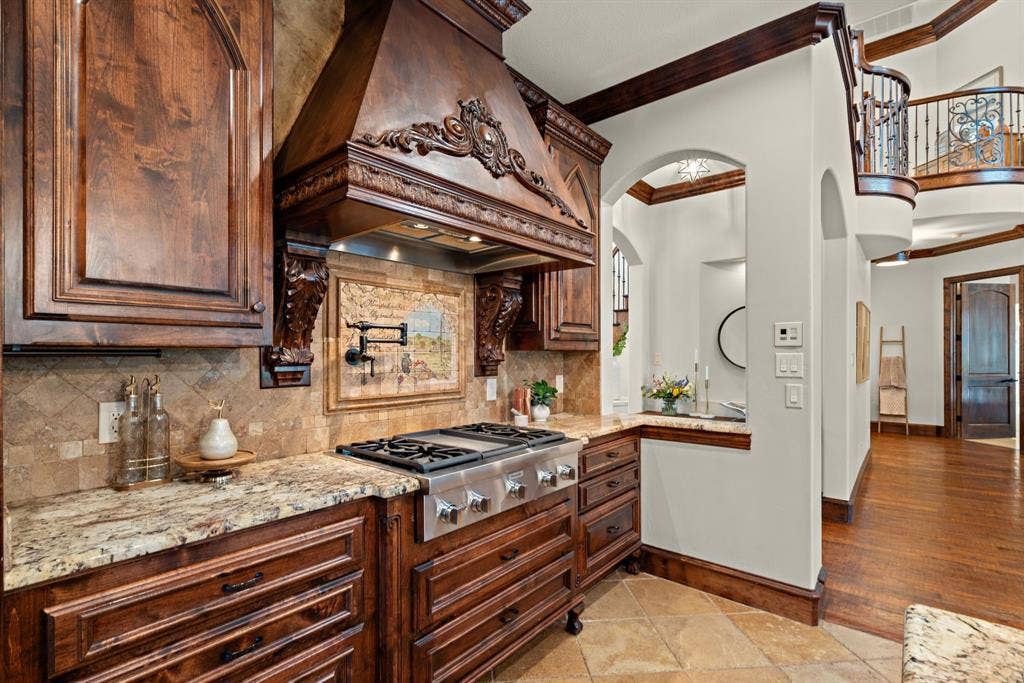 Gourmet kitchen with custom wood cabinetry, granite countertops, and a professional-grade gas range