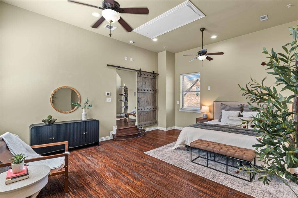 5th bedroom (no closet) is plumbed for a full en-suite bathroom and has wood-finish flooring, high ceilings with ceiling fans, recessed lighting, and a sliding barn door