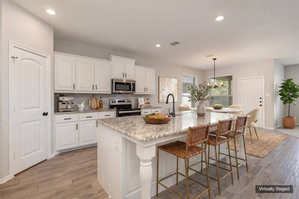 928 Dove Cove, Argyle, TX 76226 Virtually Staged View of kitchen and dining area. Large kitchen island with designated sitting area, sink, granite countertops.