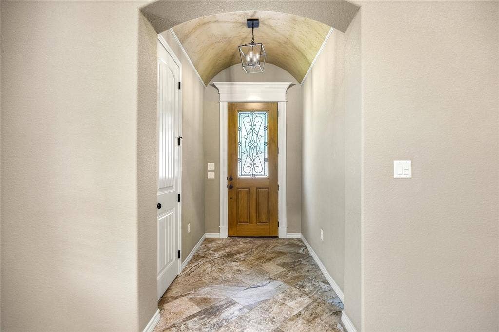 Barrel ceiling and custom woodwork frame this charming & generous entry.