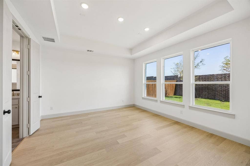 2312 Wispy Lane, Celina, TX 75009 High ceilings, lovely flooring and a wall of windows create a peaceful and relaxing owner's suite.