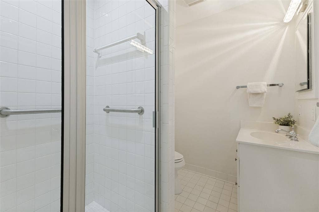 A walk-in shower is featured in this hall bath, conveniently located near the kitchen and secondary bedrooms.