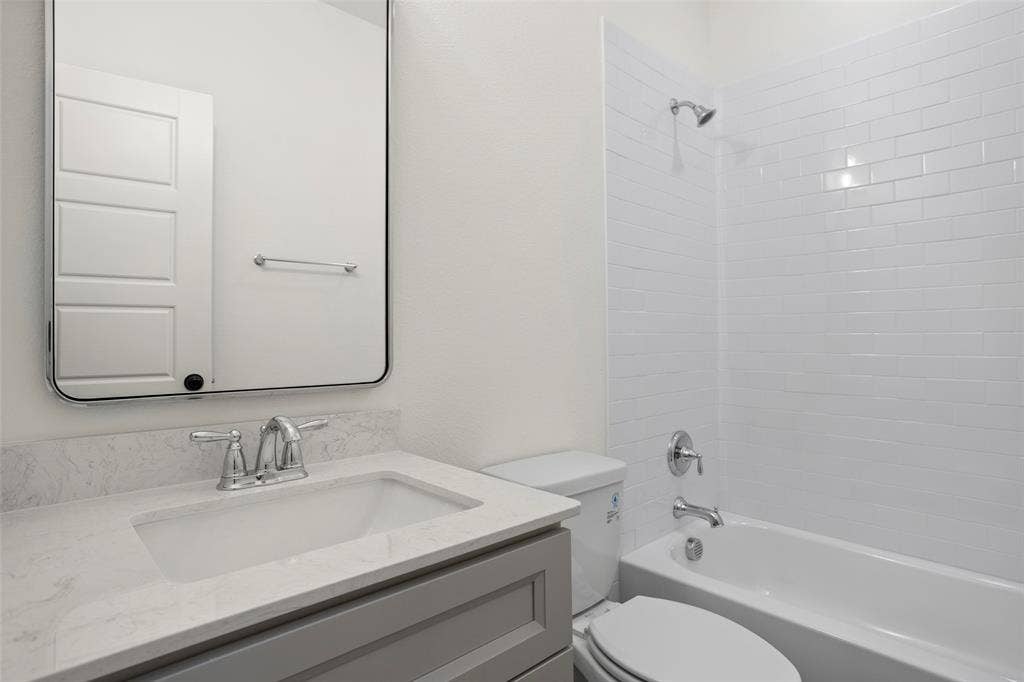 200 Cliff Court, Godley, TX 76044 Full bathroom featuring vanity, tiled shower / bath combo, and toilet