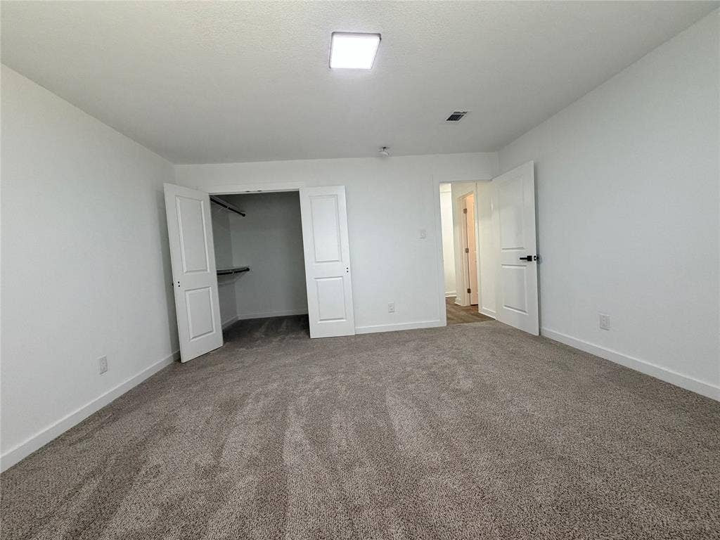 Plush carpet flooring, white interior walls, white paneled doors, closet with built-in shelving, and recessed lighting