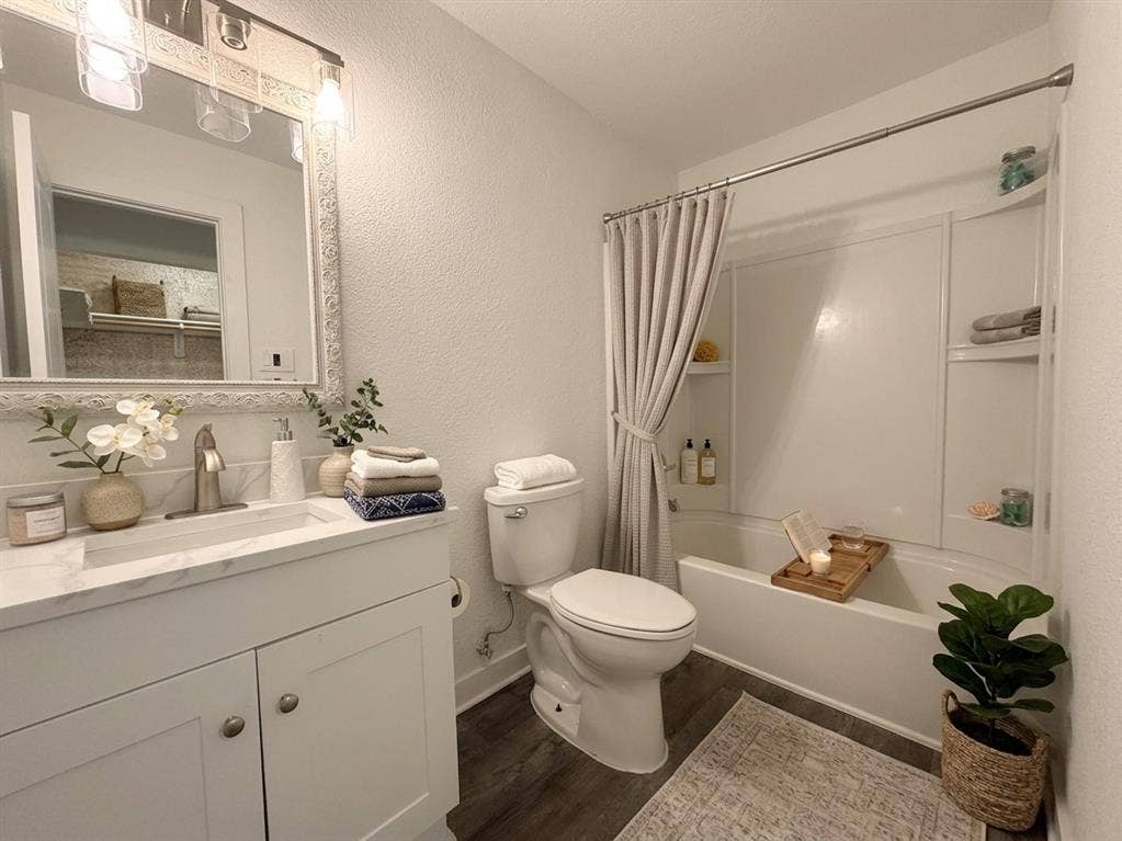 Staged- Vanity with a single basin sink, white cabinetry, and a light-colored countertop