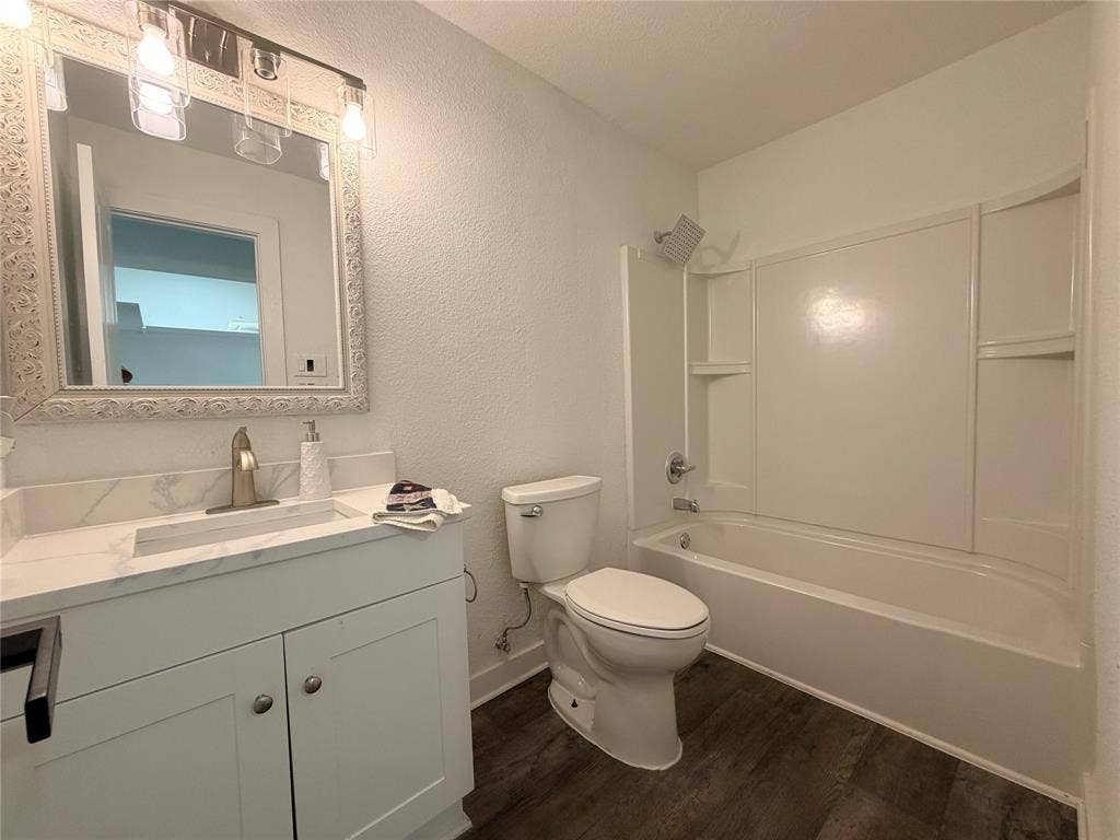 Vanity with a quartz countertop, integrated sink, and brushed nickel faucet