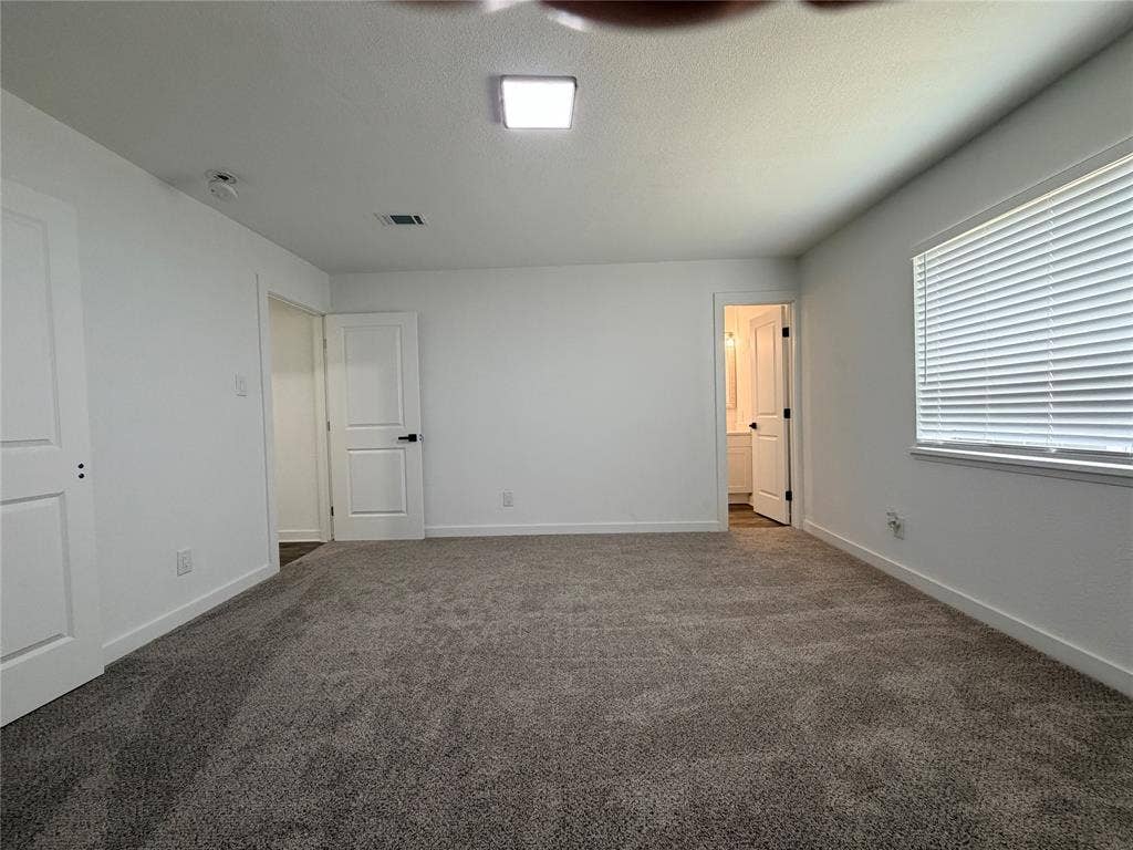 Plush gray carpeting, white walls, and a square ceiling light fixture